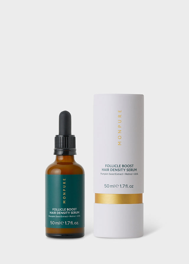 Amber glass bottle with black dropper and green label alongside white and gold cylindrical packaging for hair density serum