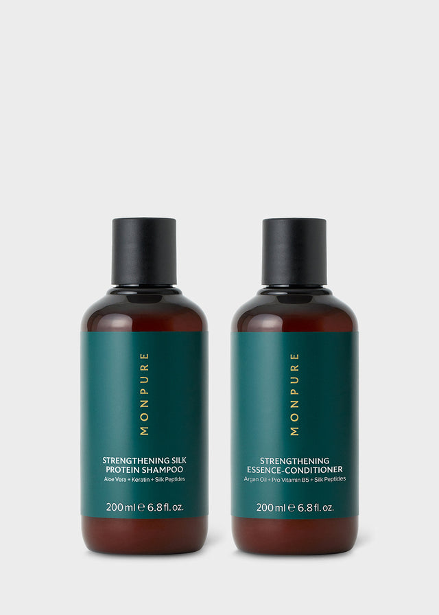 Two amber bottles with black caps containing strengthening silk protein shampoo and essence-conditioner with green labels