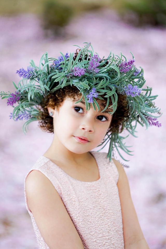 Young girl wearing a lavender flower crown and a pale pink sleeveless dress