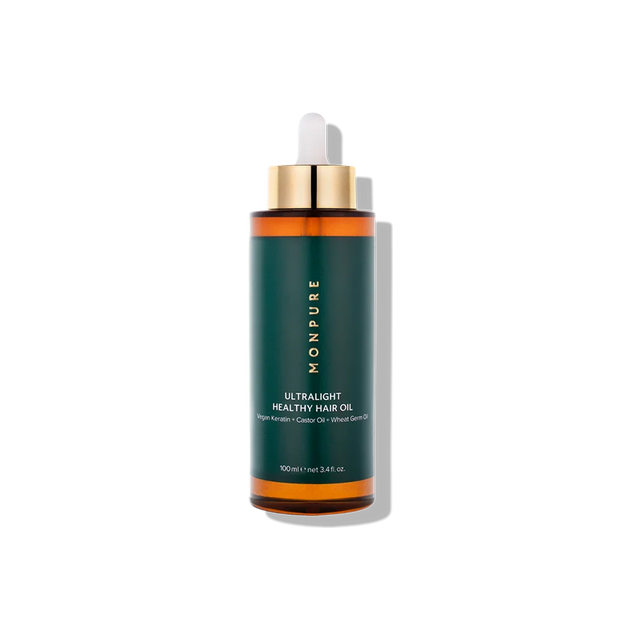 Amber glass bottle of ultralight healthy hair oil with green and gold label and dropper cap