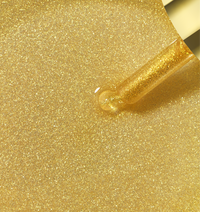 Golden shimmer and hydrate hair and body oil with glitter particles on applicator dropper