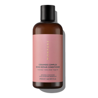 Brown bottle with pink label containing Ceramide Complex Bond Repair Conditioner with argan oil