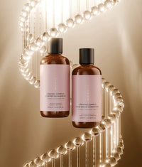 Brown bottles of Ceramide Complex Bond Repair Shampoo and Conditioner with pink labels, surrounded by glowing molecular structure