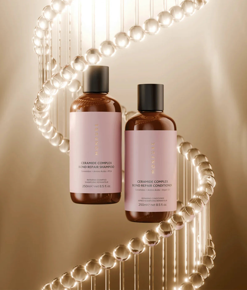 Brown bottles of Ceramide Complex Bond Repair Shampoo and Conditioner with pink labels, surrounded by glowing molecular structure