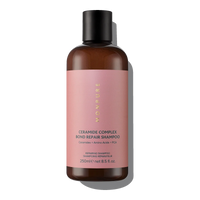 Brown bottle of Ceramide Complex Bond Repair Shampoo with pink label and black cap
