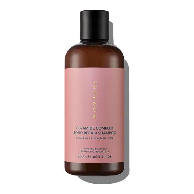 Brown bottle of Ceramide Complex Bond Repair Shampoo with pink label and black cap