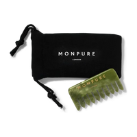 Green jade comb with wide teeth and gold Monpure branding, accompanied by black drawstring pouch
