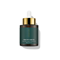 Small amber glass bottle of healthy hair oil with dark green label and gold dropper cap
